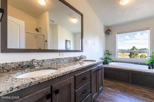 a bathroom with a granite countertop sink a large mirror a and a window