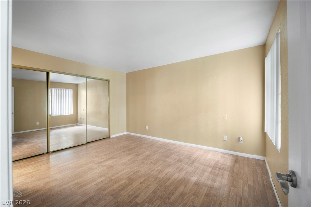 3145 East Flamingo Road, Unit 1055 Las Vegas, NV 89121 - Photo 24 of 40 Mirrored closet doors and durable wood flooring characterize this inviting room.