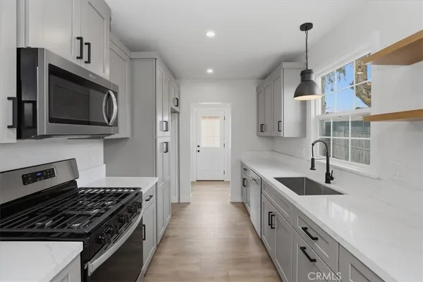 a kitchen with stainless steel appliances a sink a stove and a refrigerator