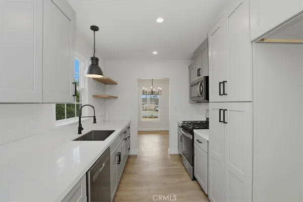 a kitchen with stainless steel appliances granite countertop a sink and a stove
