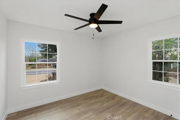 an empty room with a window and ceiling fan