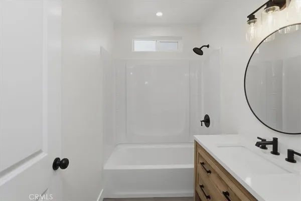 an empty room with wooden floor ceiling fan and windows
