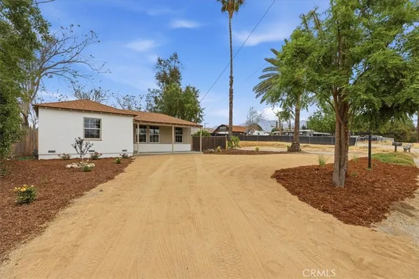 a view of a house with backyard and a tree