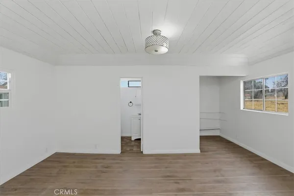 a view of a room with wooden floor and white walls