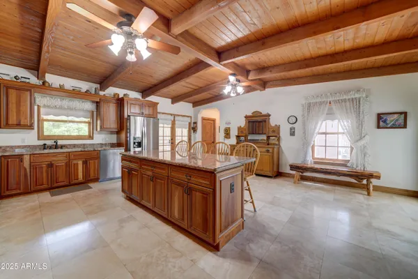 a large kitchen with stainless steel appliances wooden floors and a view of living room