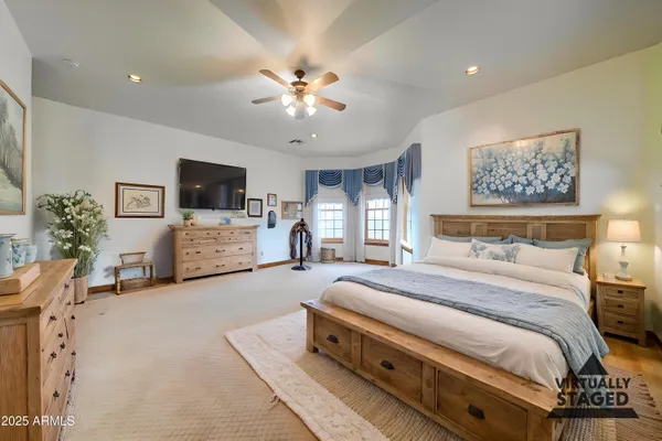 a spacious bedroom with a bed and a flat screen tv