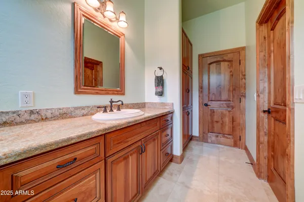 a spacious bathroom with a granite countertop sink mirror and a shower