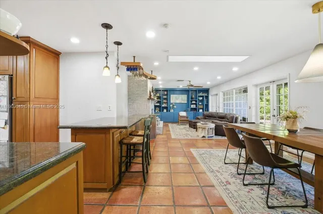 a dining room with kitchen island a table and chairs