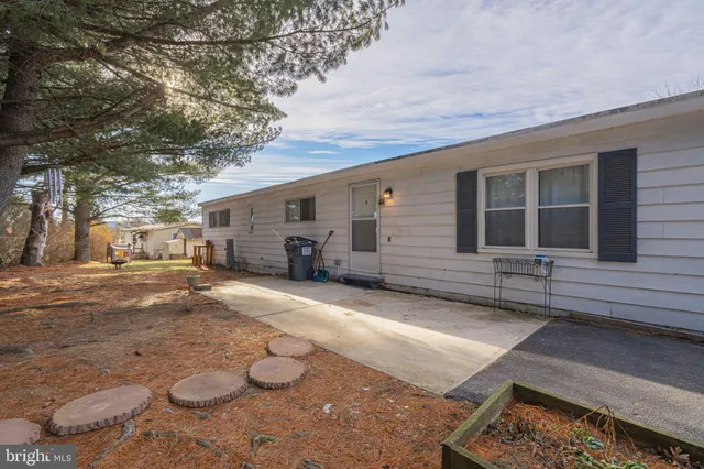 a backyard of a house with table and chairs under an umbrella