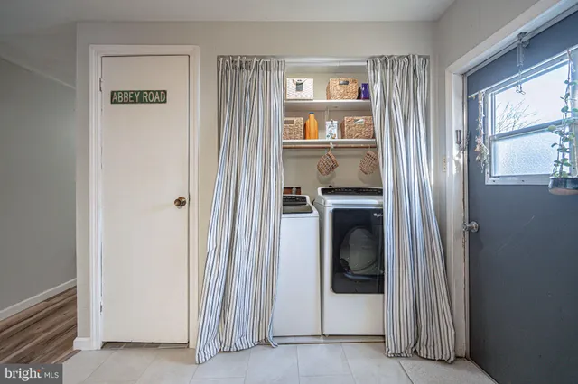 a living room with furniture a flat screen tv and a floor to ceiling window