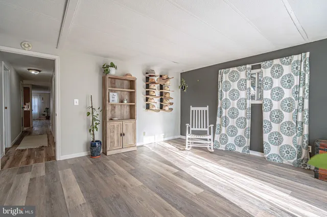 a view of a livingroom with wooden floor and a flat screen tv