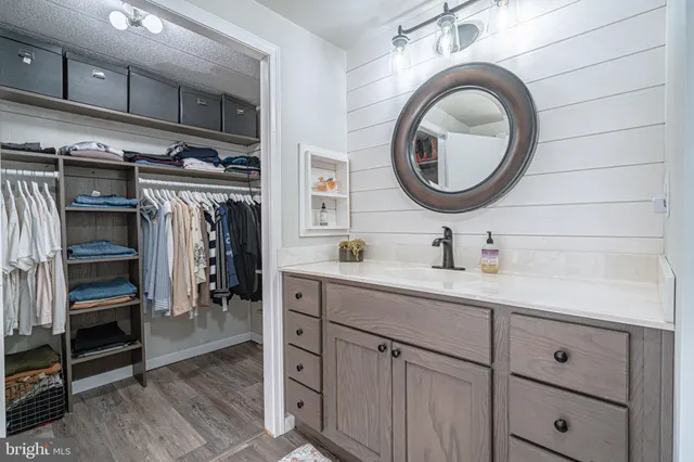 a view of walk in closet with clothes and shoes