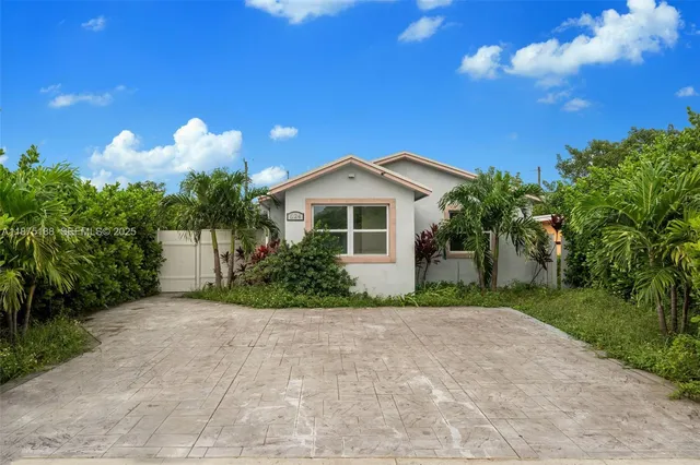a front view of a house with a yard and potted plants