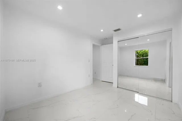 an empty room with windows and closet