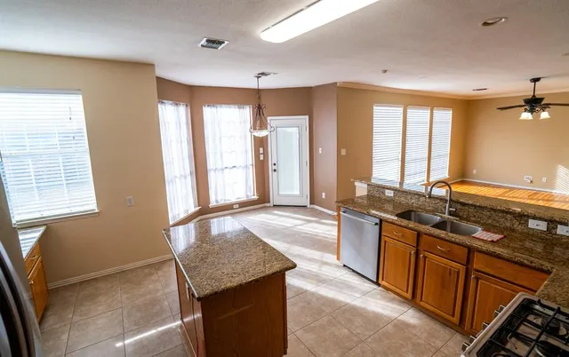 a large kitchen with kitchen island granite countertop a large window