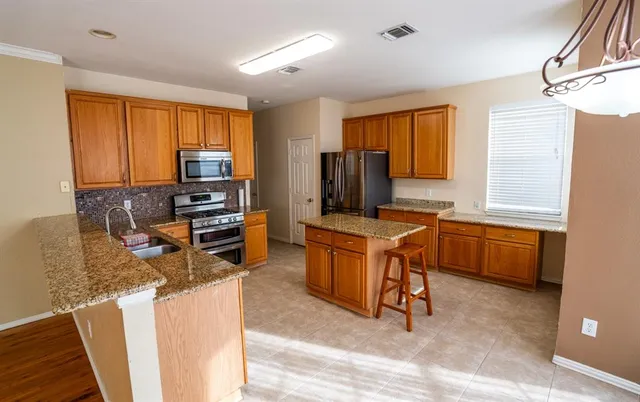 a kitchen with a refrigerator stove top oven and sink