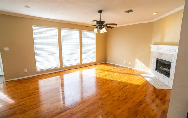 a view of an empty room with a window and wooden floor