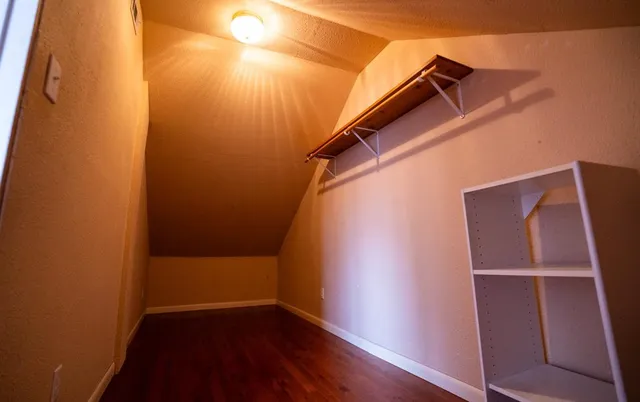 a view of walk in closet with clothes and shoes