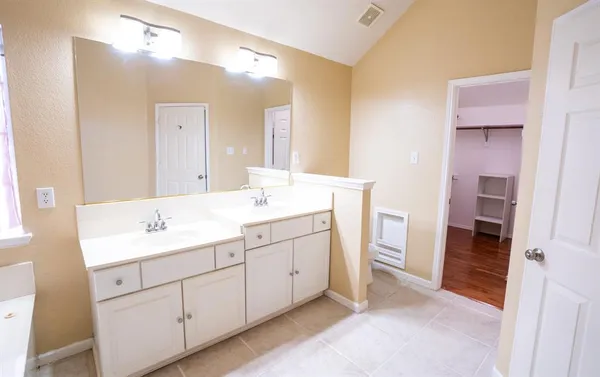 a spacious bathroom with a double vanity sink a and a mirror