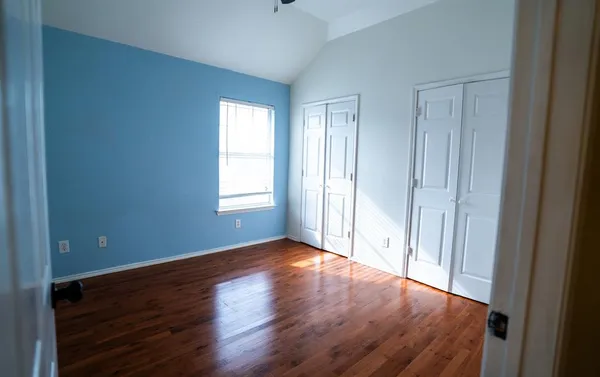 a view of a room with wooden floor and a chandelier