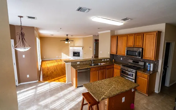 a kitchen with stainless steel appliances granite countertop a sink stove and refrigerator