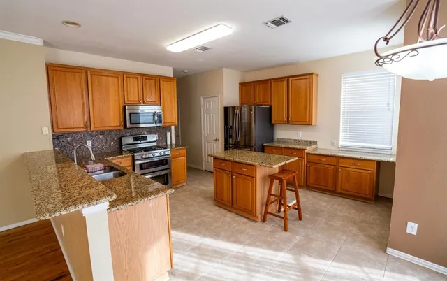 a kitchen with a sink appliances cabinets and furniture