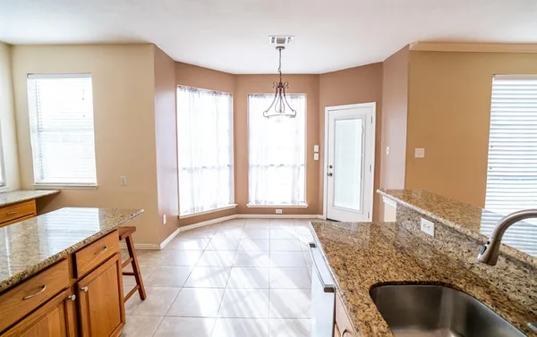 a bathroom with a granite countertop sink a bathtub and next to a window