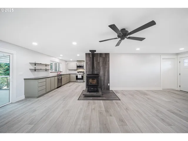 a living room with stainless steel appliances kitchen island granite countertop a wooden floors