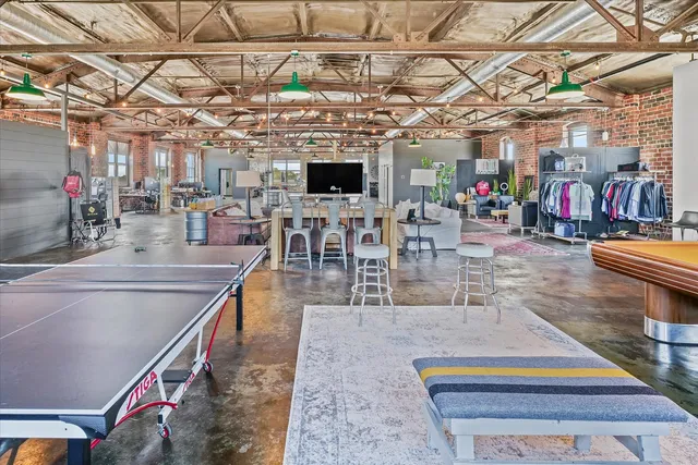 a dining room with furniture a chandelier and kitchen view