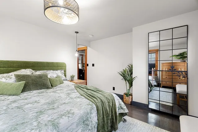 a bedroom with a large bed and a chandelier