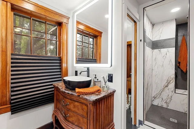 a bathroom with a granite countertop sink and a mirror