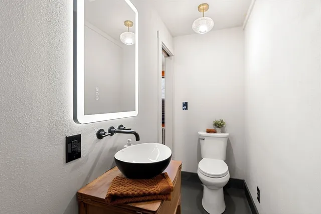 a bathroom with a toilet a sink and mirror