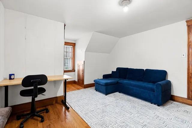 a living room with couches rug and a large window