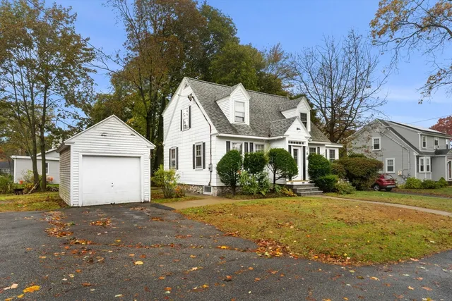 a view of a white house with a yard and large tree