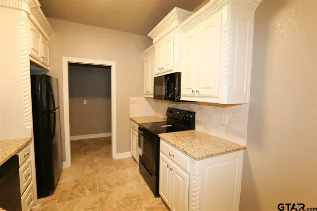 a kitchen with a stove a refrigerator and a microwave