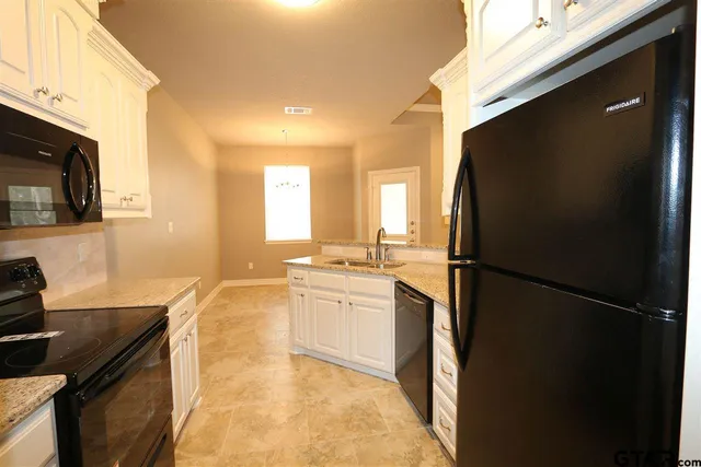 a kitchen with a refrigerator and a sink