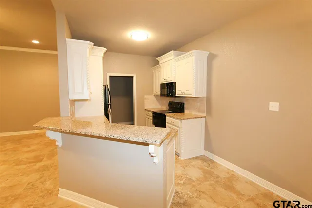 a kitchen with stainless steel appliances granite countertop a refrigerator a stove and a sink