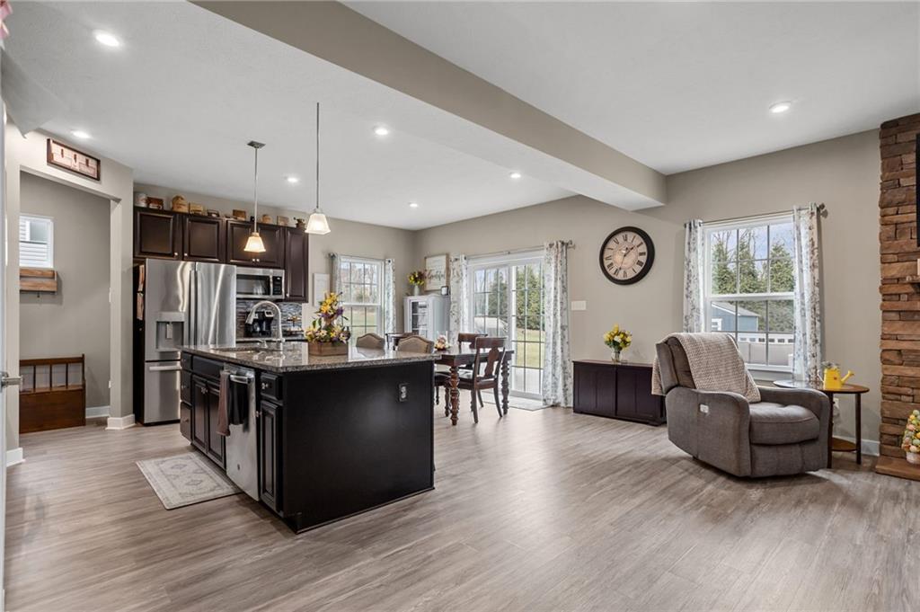1075 Blackhawk Road Valencia, PA 16059 - Photo 6 of 25 a kitchen with stainless steel appliances granite countertop a stove top oven a refrigerator a dining table and chairs with wooden floor