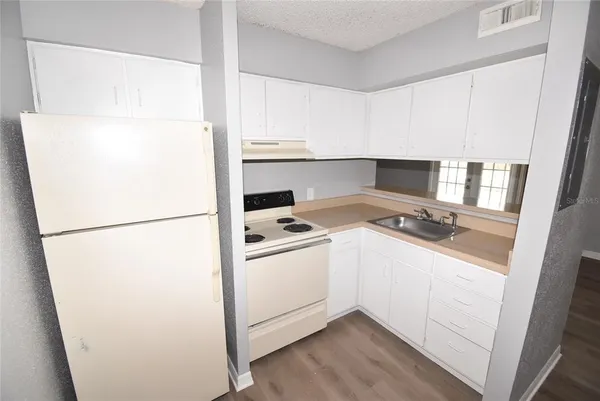 a kitchen with a refrigerator sink stove and cabinets