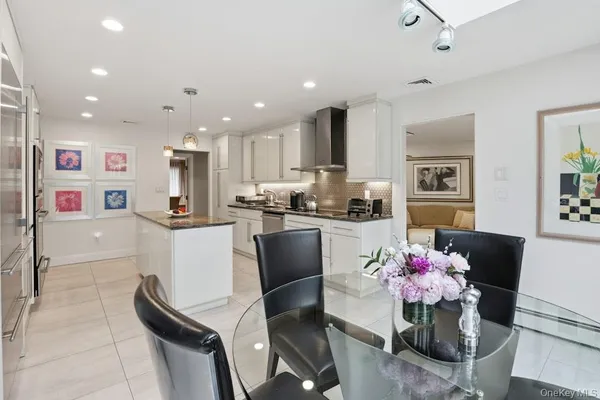 a spacious bedroom with a bed a chandelier and dresser