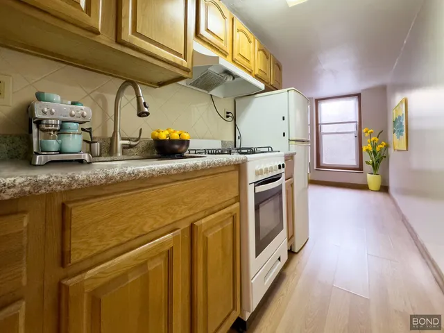 a kitchen with stainless steel appliances granite countertop a sink and wooden cabinets