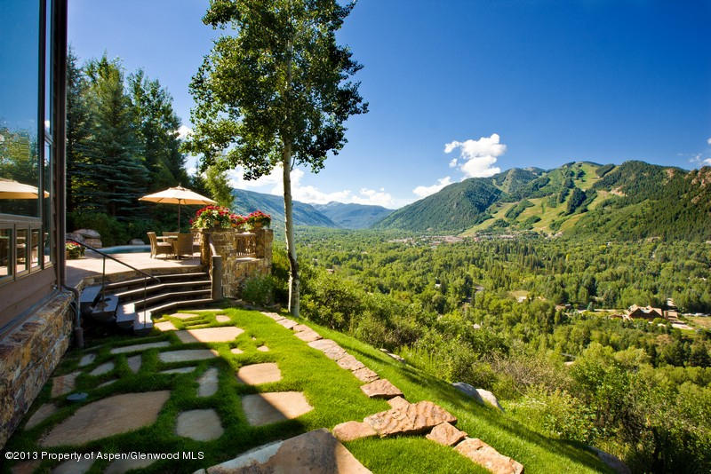 10 Ridge Place Aspen, CO 81612 - Photo 29 of 37 a backyard of a house with table and chairs under an umbrella
