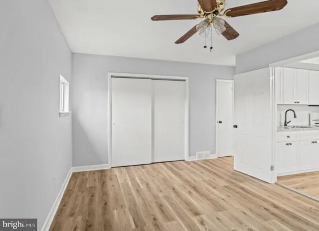 a view of a room with wooden floor and a ceiling fan