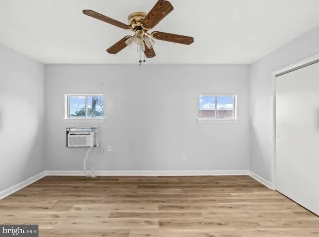 a view of a room with wooden floor and a ceiling fan