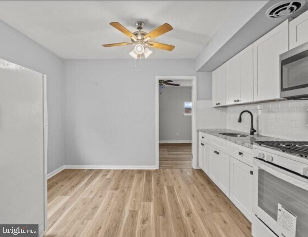 6017 North 11th Street Philadelphia, PA 19141 - Photo 4 of 13 a kitchen with stainless steel appliances granite countertop a sink stove and refrigerator