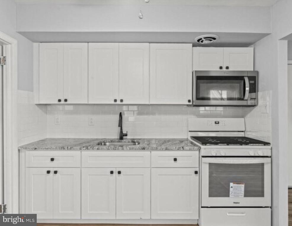 6017 North 11th Street Philadelphia, PA 19141 - Photo 6 of 13 a kitchen with granite countertop white cabinets and white appliances