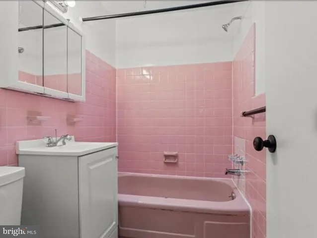 a bathroom with a sink a toilet a tub and shower