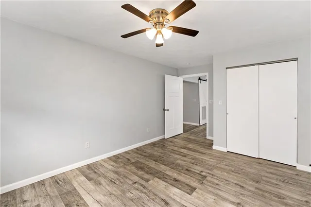 a view of a big room with wooden floor and a chandelier fan