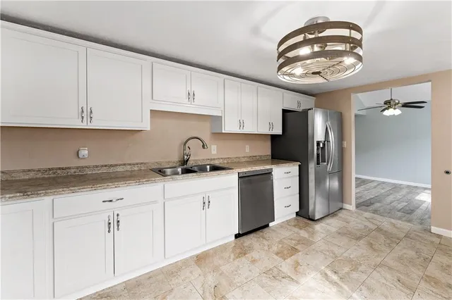 a kitchen with stainless steel appliances granite countertop a sink a stove and a refrigerator