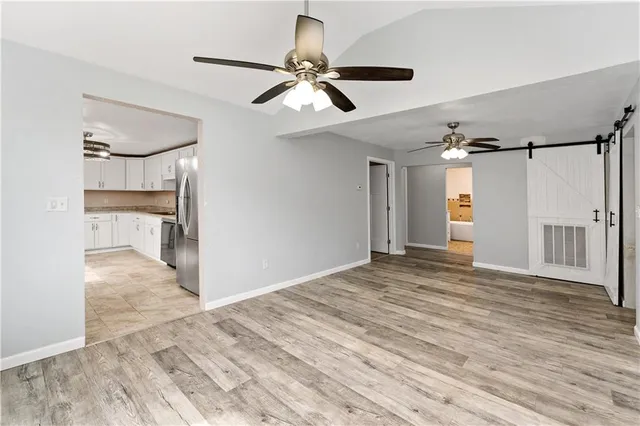 a view of empty room with wooden floor and ceiling fan